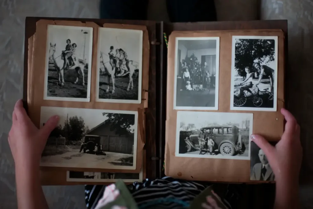 A photo showing someone holding a photo album with an array of vintage photos.
