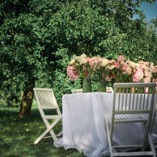 A photo showing an outdoor table and chairs set-up for a celebration of life event.