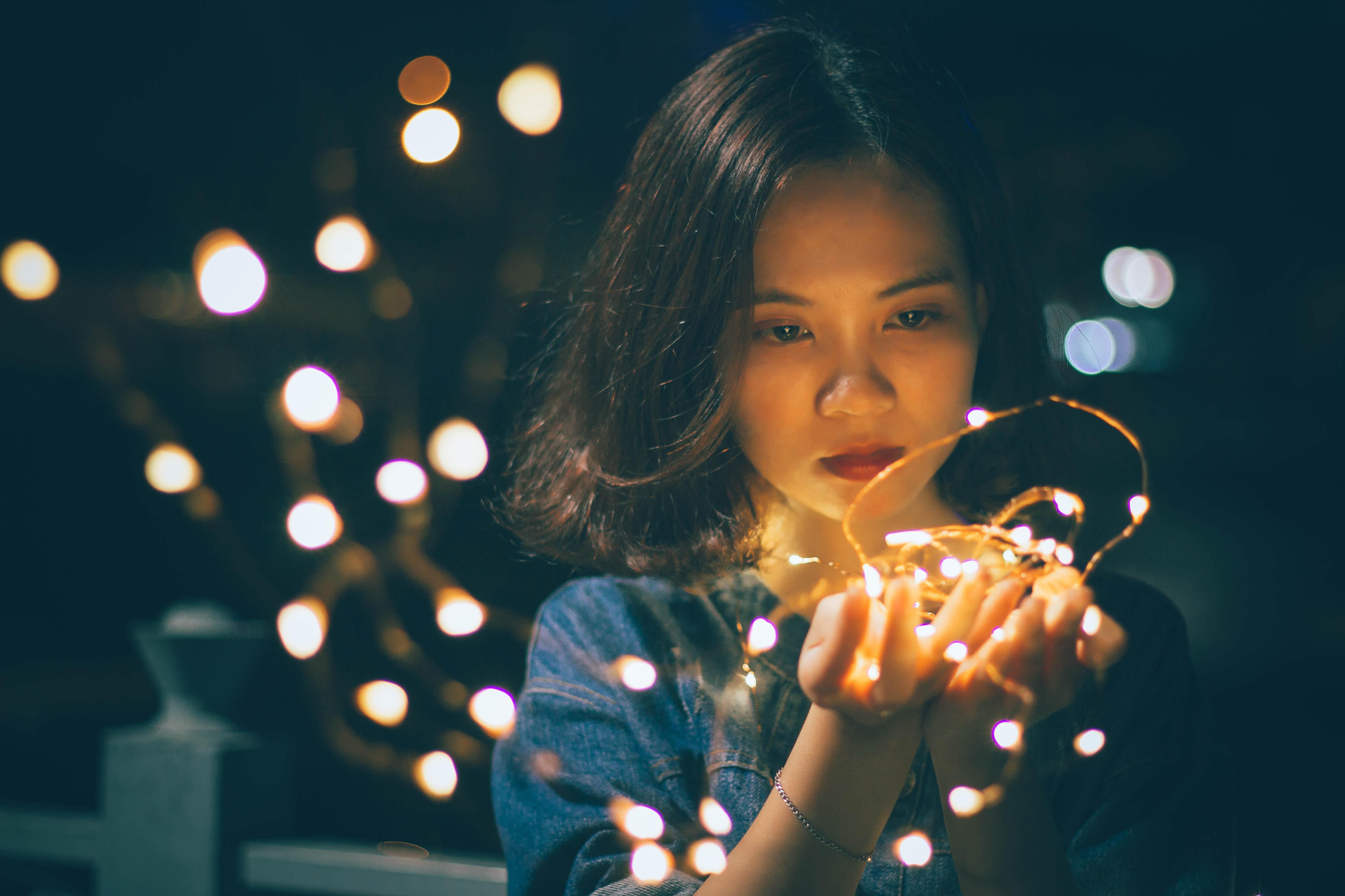 Woman holding lighted string of lights